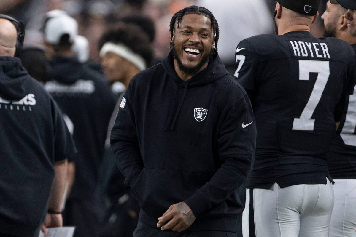 Raiders running back Josh Jacobs laughs on the sideline during the first half of an NFL game ag ...