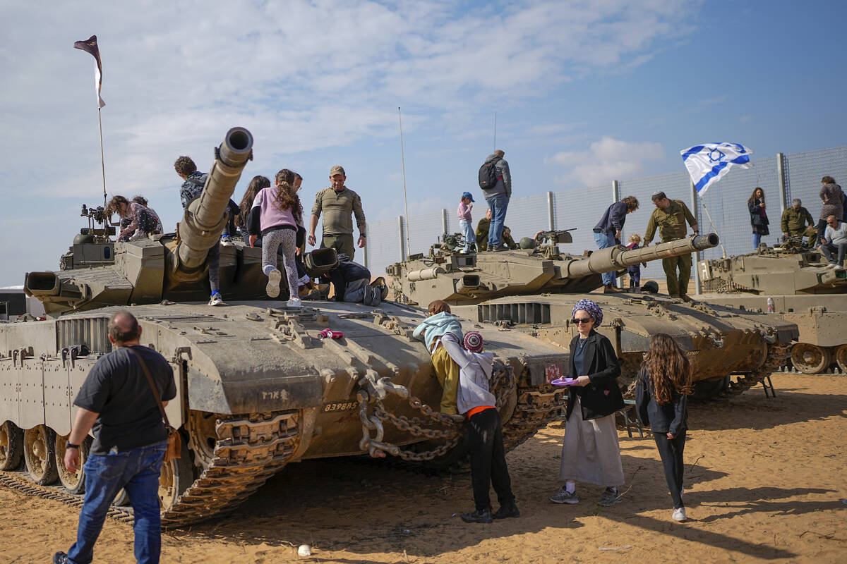 Israelis stand on tanks during an event for families of reservists outside a military base in s ...