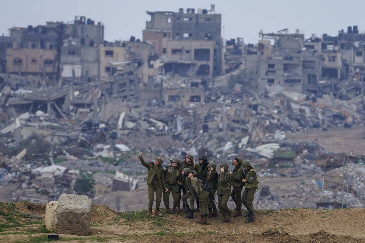 FILE - Israeli female soldiers pose for a photo on a position on the Gaza Strip border, in sout ...