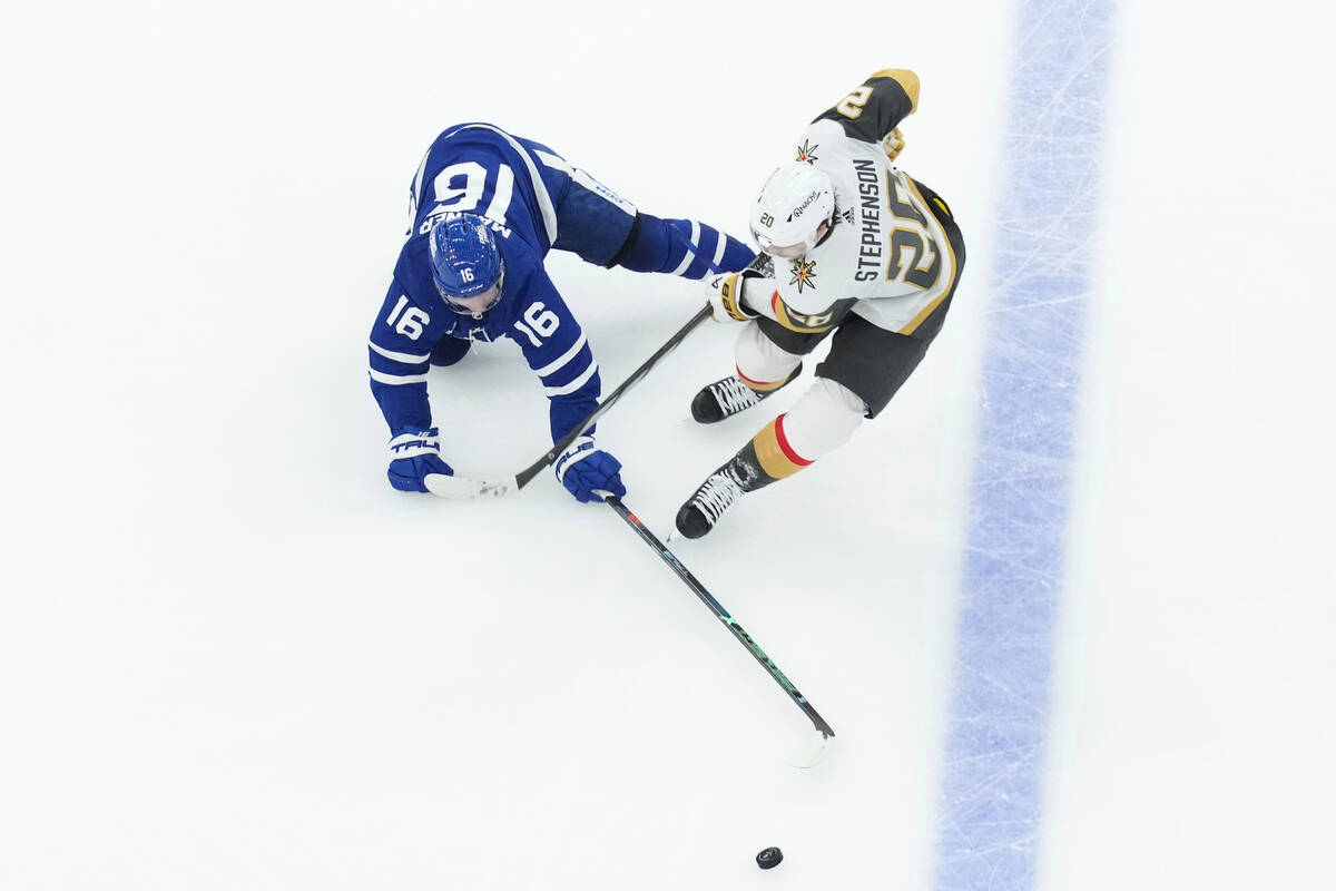 Toronto Maple Leafs' Mitchell Marner (16) and Vegas Golden Knights' Chandler Stephenson (20) go ...