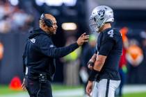 Raiders interim head coach Antonio Pierce chats with quarterback Aidan O'Connell (4) on a timeo ...