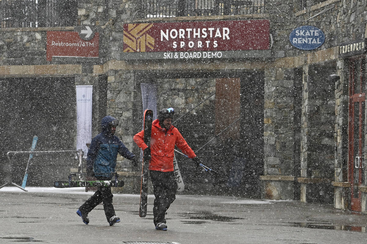 Skiers hurry along The Village at Northstar California Resort as snow falls on Thursday, Feb. 2 ...