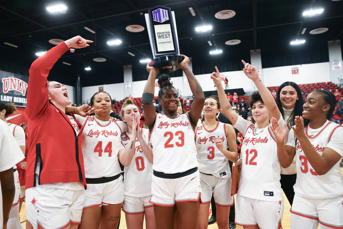 The UNLV Lady Rebels hold up their Mountain West championship trophy after clinching the title ...