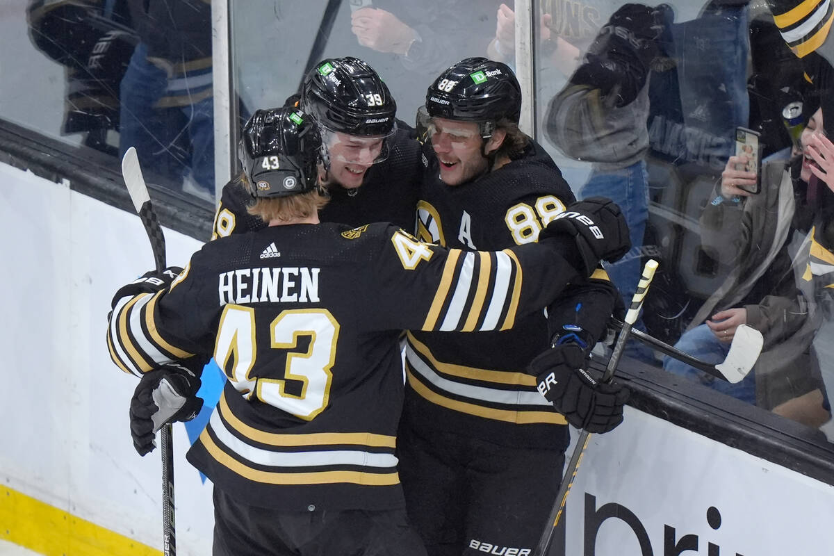 Boston Bruins center Morgan Geekie (39) celebrates with left wing Danton Heinen (43) and right ...