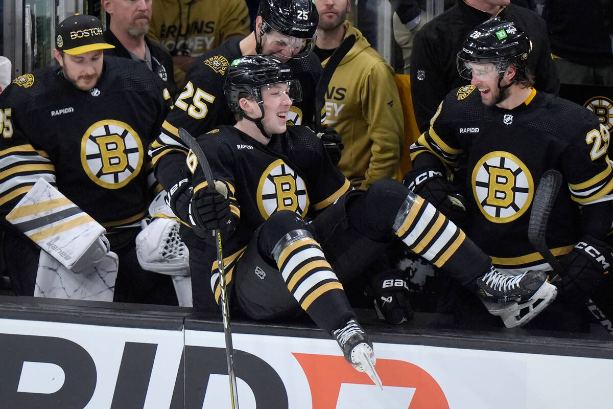 Boston Bruins defenseman Mason Lohrei, center, celebrates with teammates on the bench after sco ...