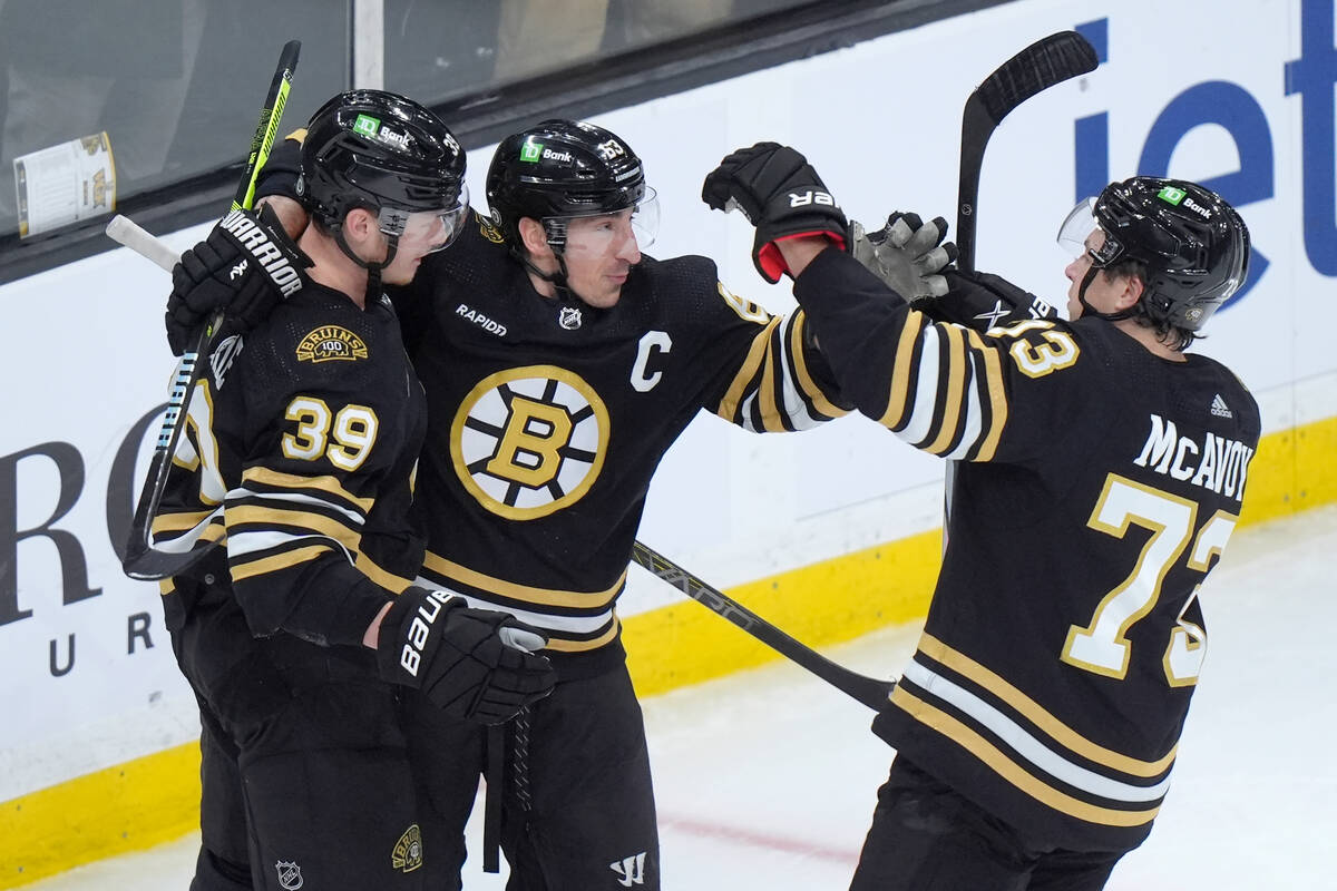 Boston Bruins center Morgan Geekie (39) celebrates with left wing Brad Marchand (63) and defens ...