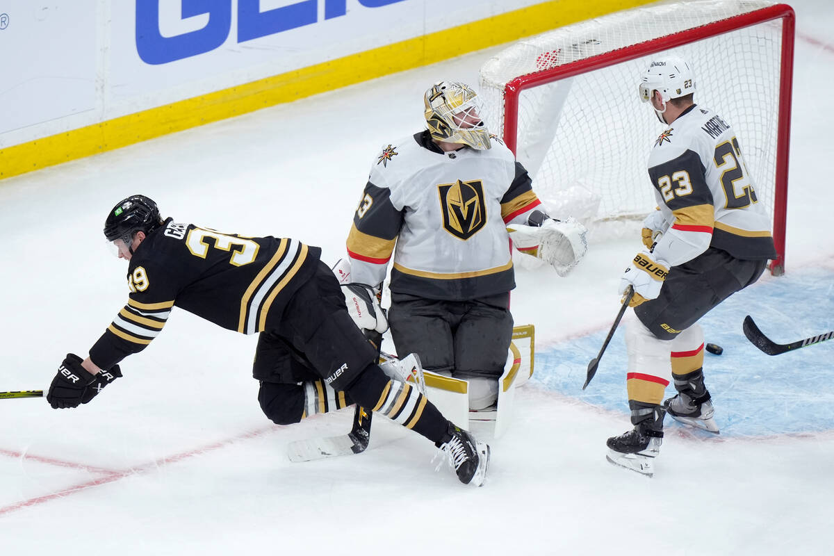 Boston Bruins center Morgan Geekie, left, hits the ice after he scored in front of Vegas Golden ...
