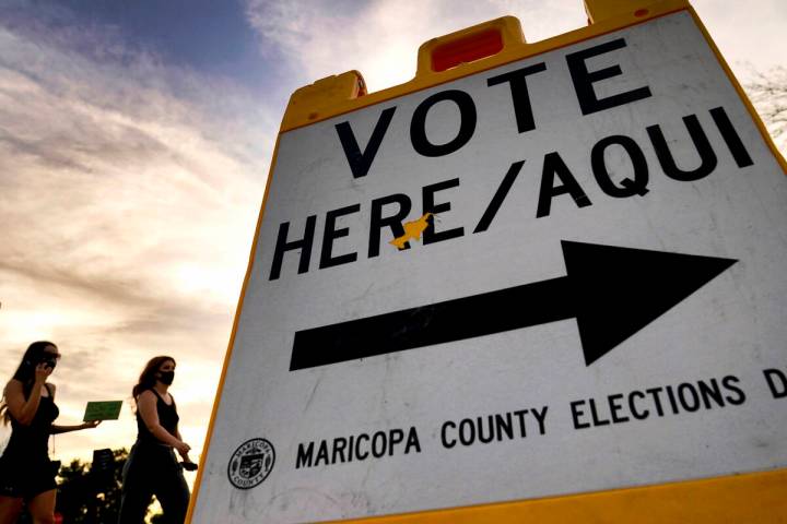 Voters deliver their ballot to a polling station in Tempe, Ariz., on Nov. 3, 2020. In a ruling ...