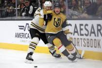 Bruins defenseman Kevin Shattenkirk (12) works to delay Golden Knights center Jack Eichel (9) a ...