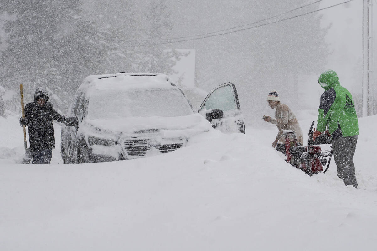 Residents try to clear snow during a storm, Saturday, March 2, 2024, in Truckee, Calif. (AP Pho ...