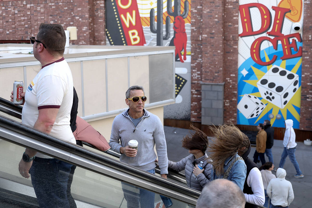 Visitors to the Las Vegas Strip traverse Las Vegas Boulevard as a high wind warning is in effec ...