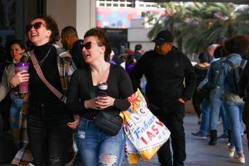 Visitors to the Las Vegas Strip brave gusts as a high wind warning is in effect on Saturday, Ma ...