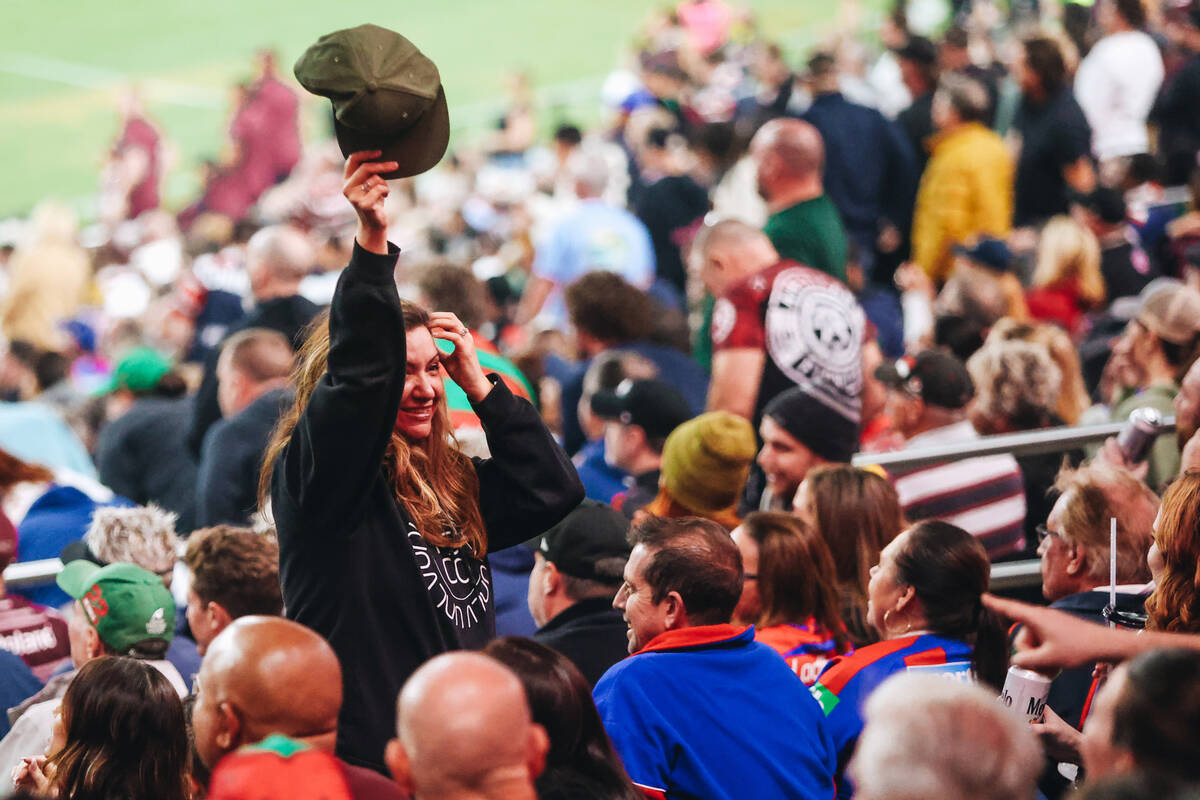 A fan waves her hat during a rugby match between the Sea Eagles and Rabbitohs during the NRL Te ...