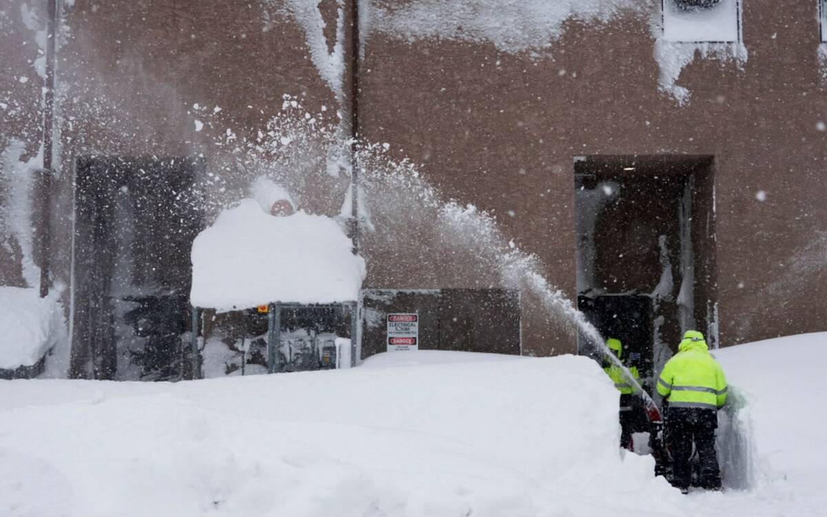 Snow is cleared from the entrance to a business during a storm, Sunday, March 3, 2024, in Truck ...