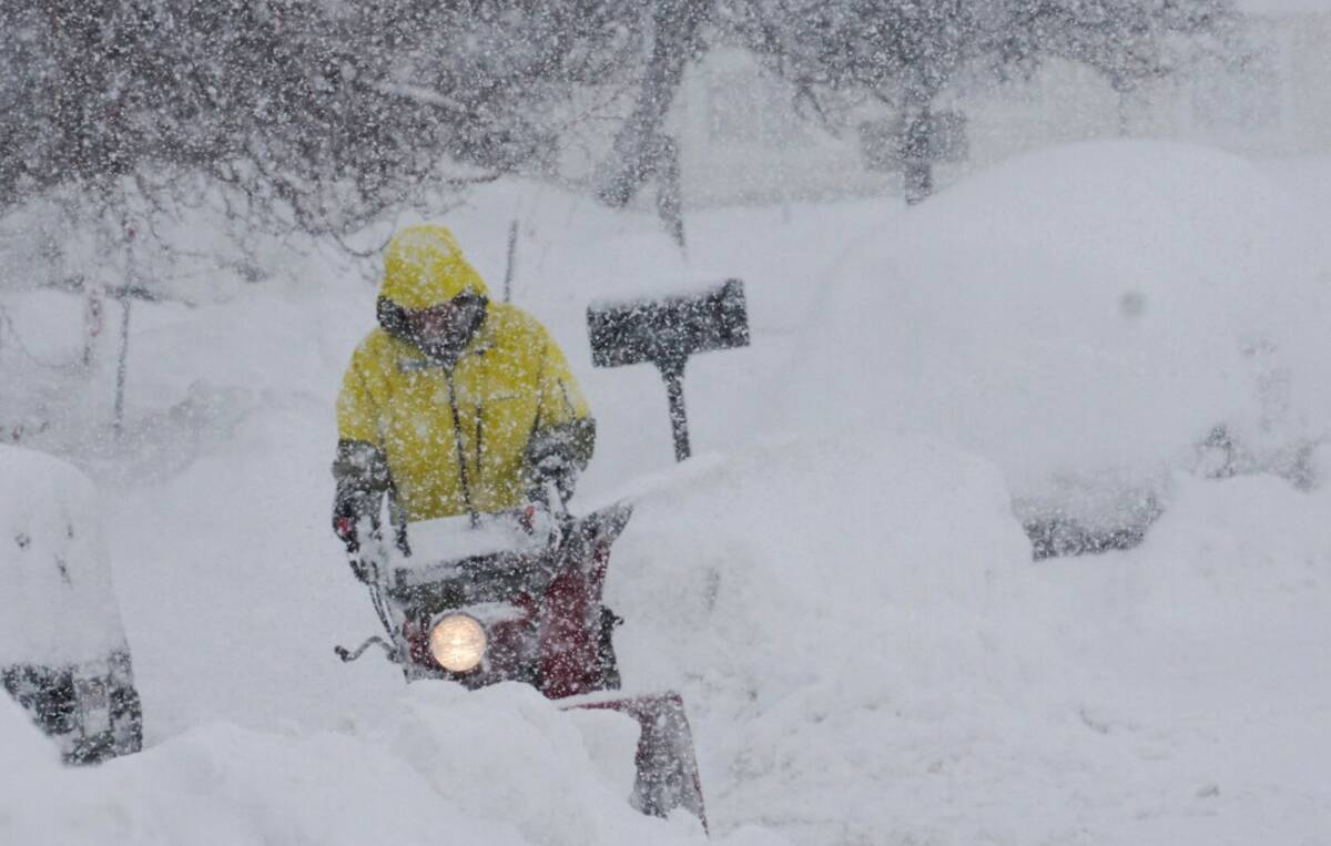 A person uses a blower to clear snow during a storm, Sunday, March 3, 2024, in Truckee, Calif. ...