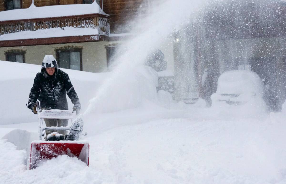 Snow is cleared from a sidewalk during a storm, Sunday, March 3, 2024, in Truckee, Calif. (AP P ...