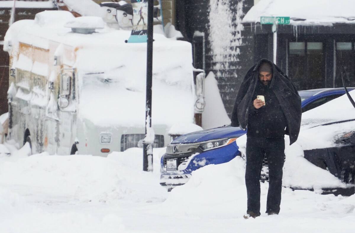 A man covers his head with a jacket during a storm, Sunday, March 3, 2024, in Truckee, Calif. ( ...