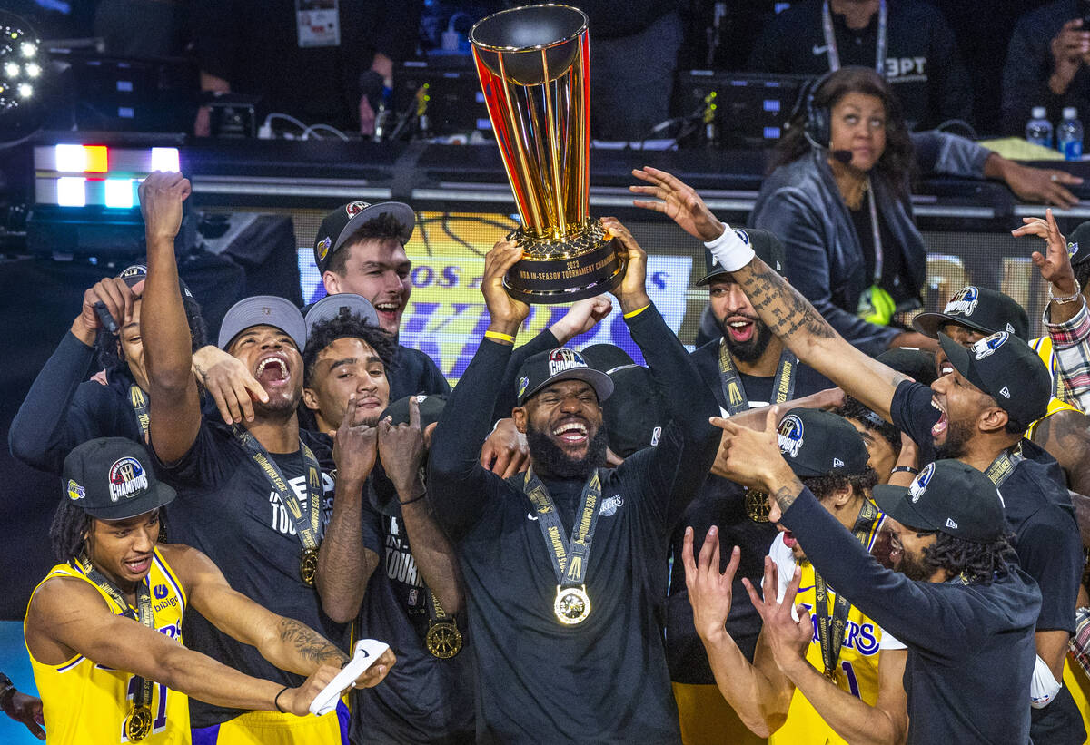 Los Angeles Lakers forward LeBron James (23) holds up the winning trophy about teammates after ...