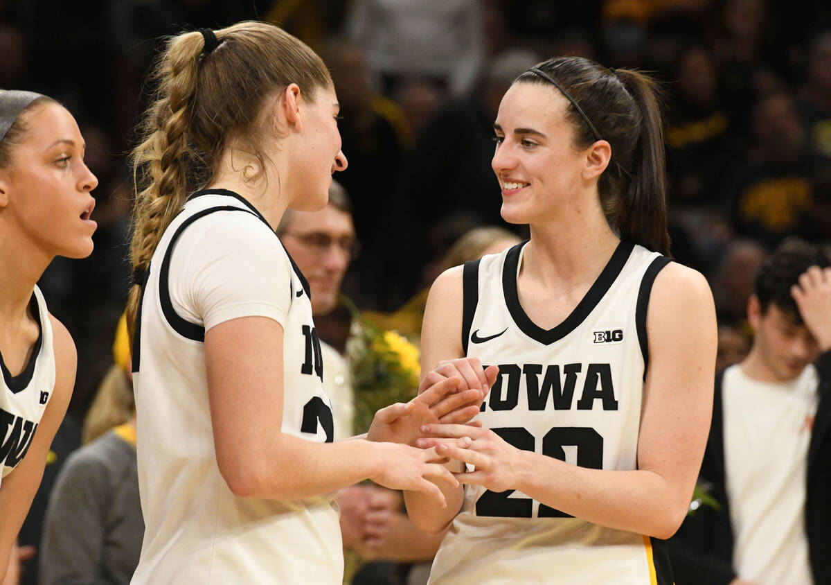 Iowa guards Kate Martin, second from left, greets Iowa guard Caitlin Clark (22) after they were ...