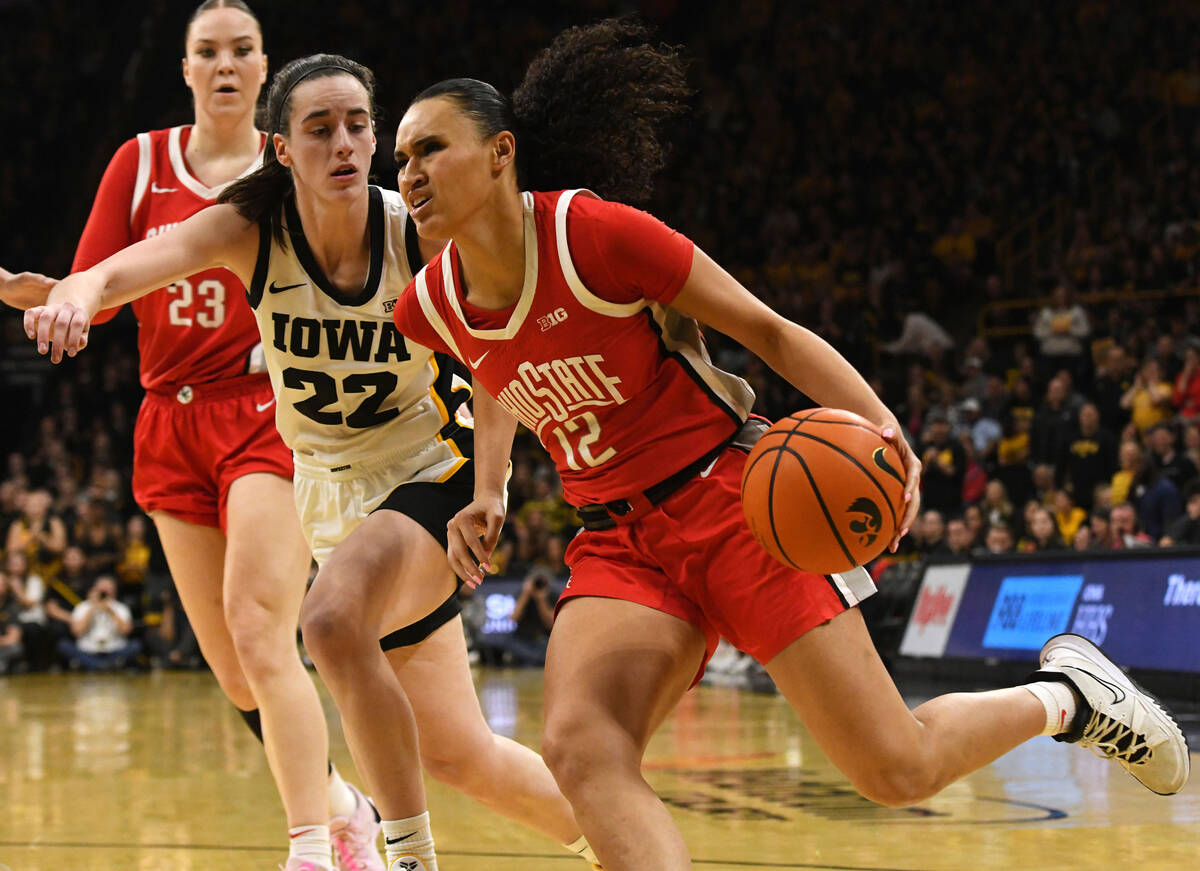 Ohio State guard Celeste Taylor (12) drives to the basket under pressure from Iowa guard Caitli ...