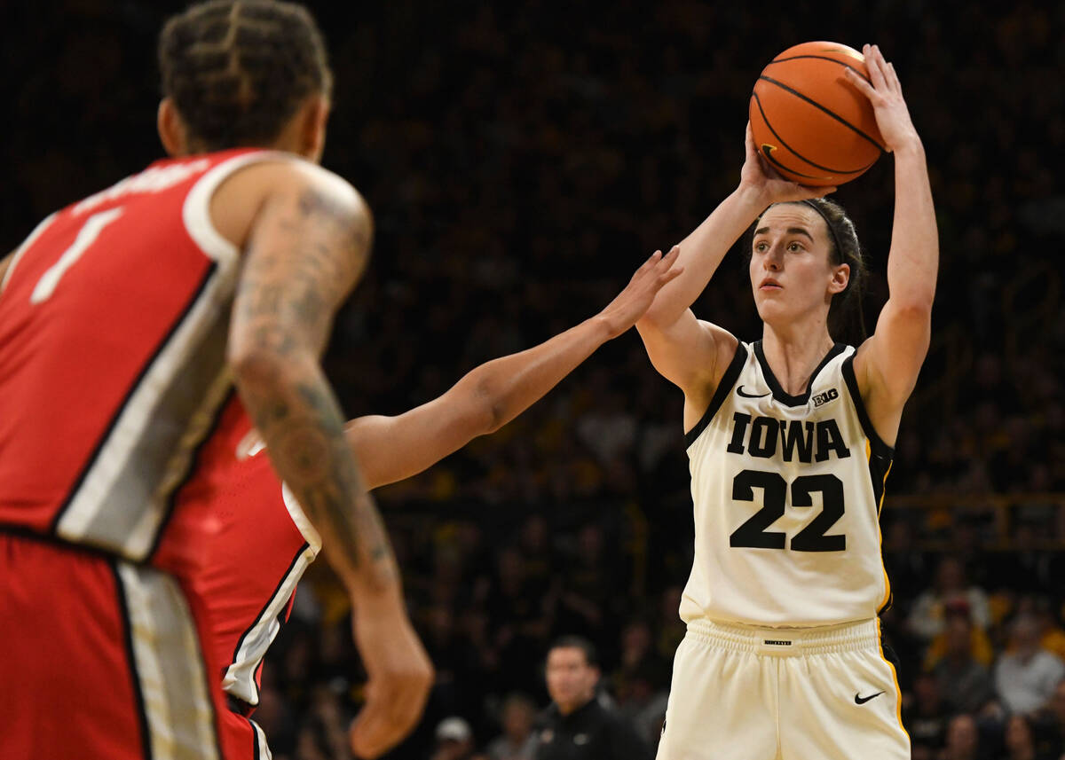 Iowa guard Caitlin Clark (22) takes a 3-point shot over Ohio State defenders during the second ...