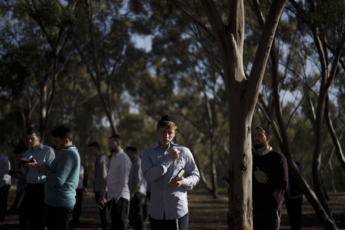 A young Jewish man prays as he visits the site where revelers were killed and kidnapped during ...