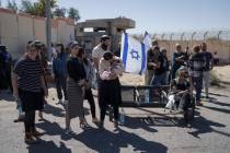 People gather at Israel's Nitzana border crossing with Egypt in southern Israel, Tuesday, March ...