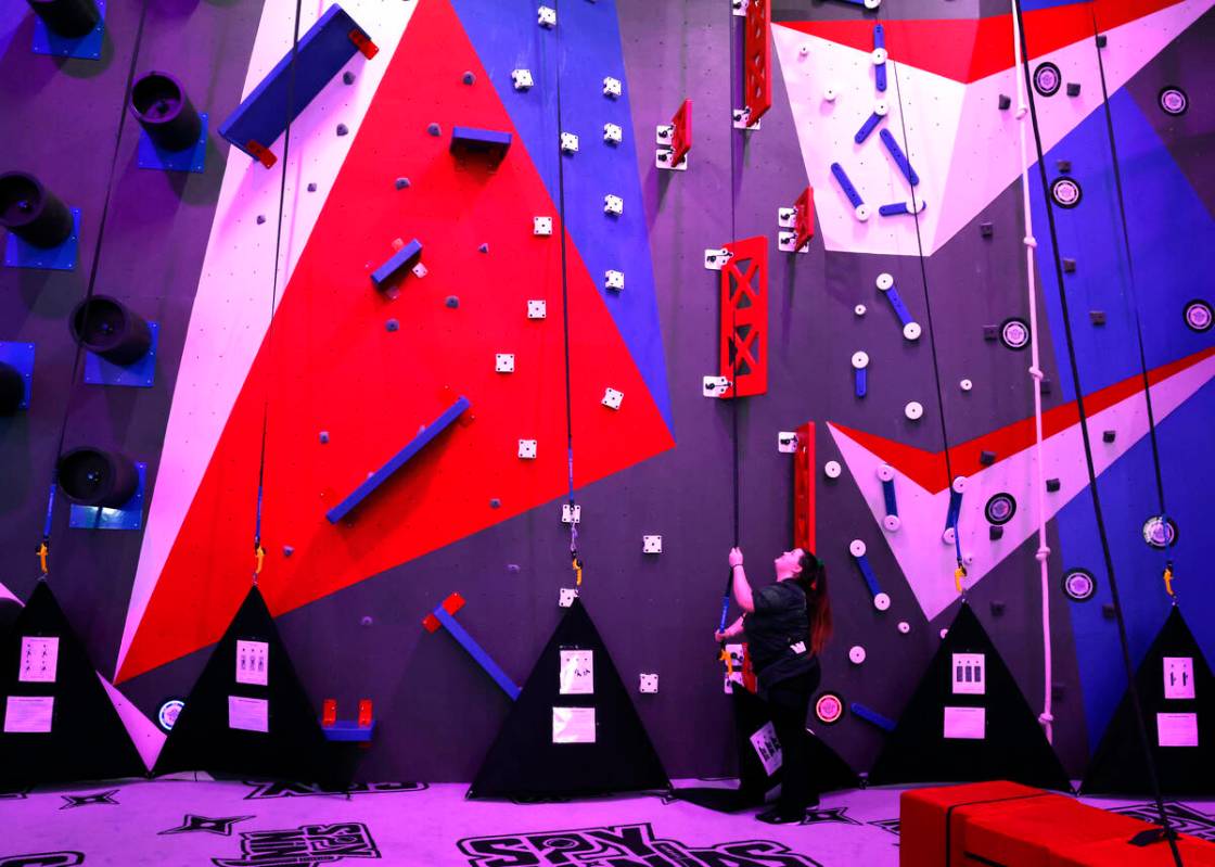 Reina Ochoa, an attraction agent, inspects Chad's Wild Climb's belays at Spy Ninja HQ, the Worl ...