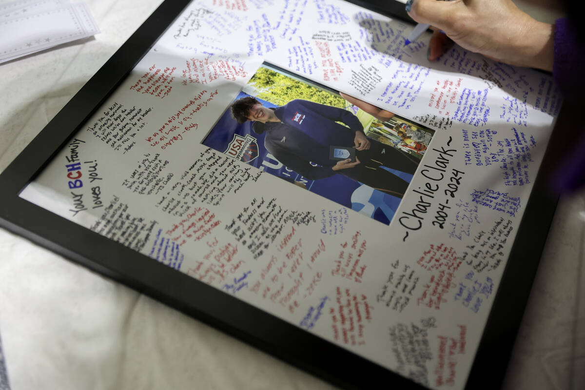 Community members sign a photo during a vigil for star swimmer for Charlie Clark, 19, at Hender ...