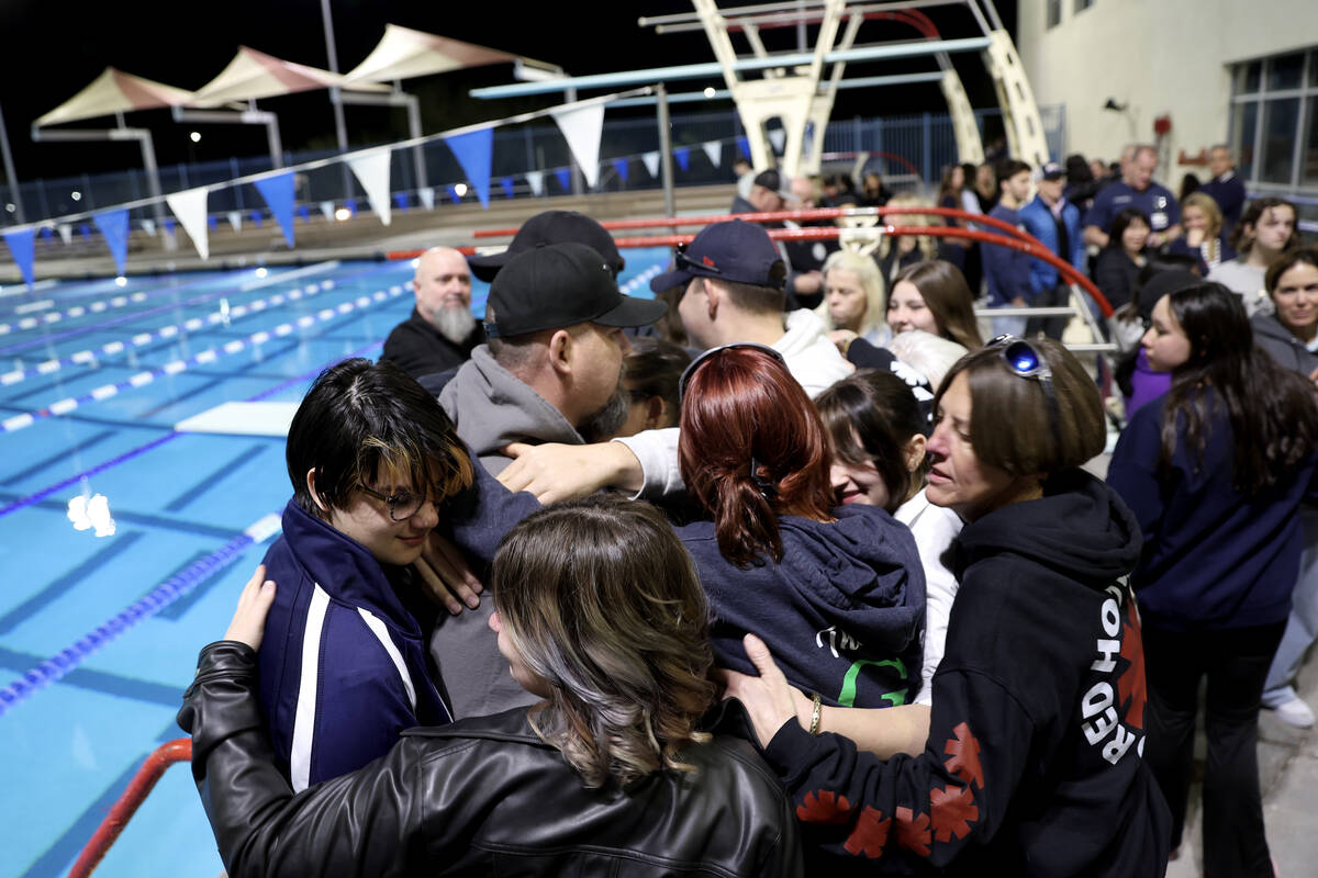 Loved ones of star swimmer Charlie Clark, 19, form a group hug during a vigil at Henderson Mult ...