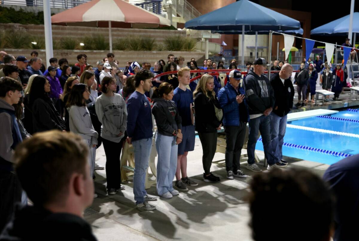 Loved ones of star swimmer Charlie Clark, 19, stand in a moment of silence during a vigil at He ...