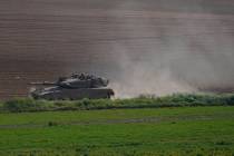 Israeli soldiers move on the top of a tank near the Israeli-Gaza border as seen from southern I ...