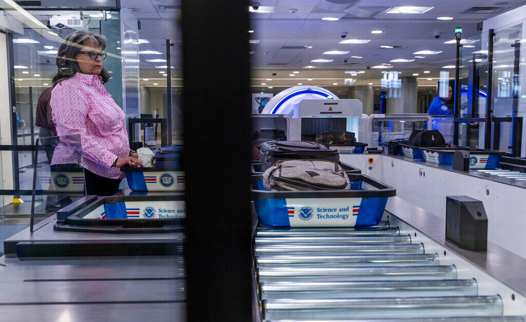A Transportation Security Administration employee demonstrates a self-service passenger screeni ...