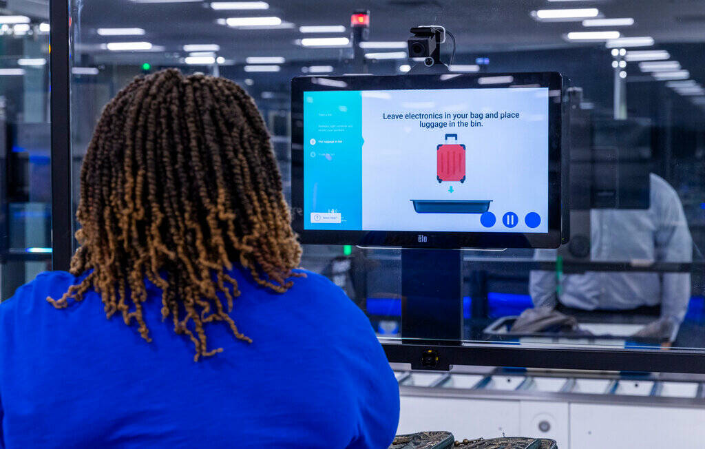 A Transportation Security Administration employee demonstrates a self-service passenger screeni ...