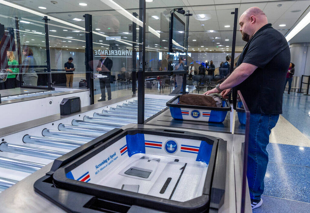 A Transportation Security Administration employee demonstrates a self-service passenger screeni ...