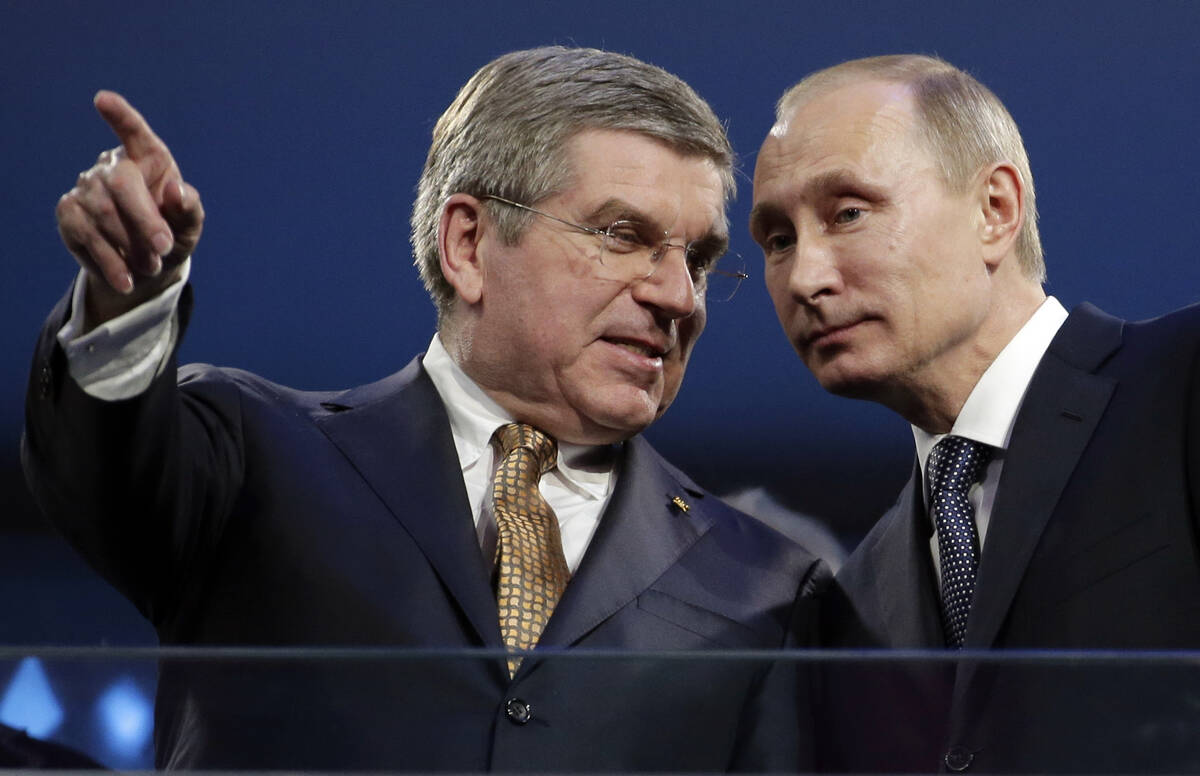 International Olympic Committee President Thomas Bach, left, and Russian President Vladimir Put ...