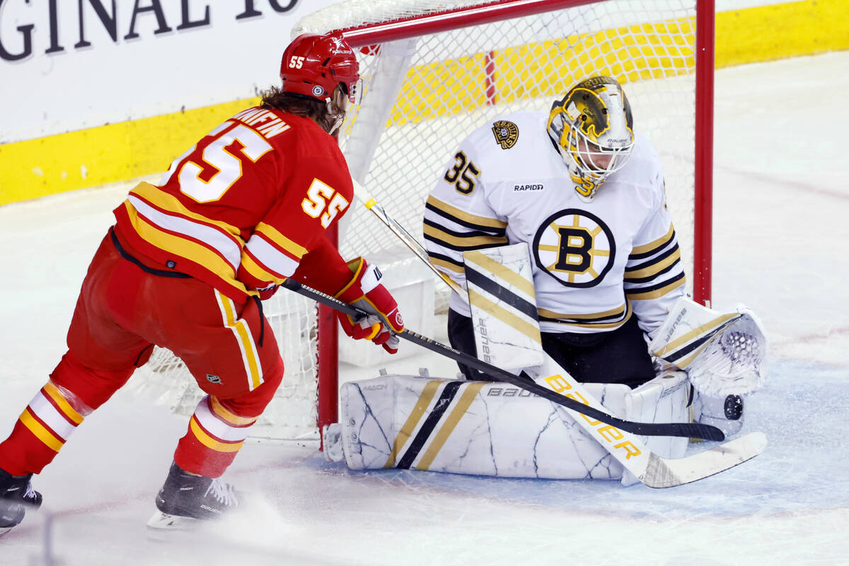 Boston Bruins goalie Linus Ullmark makes a save against Calgary Flames' Noah Hanifin during the ...