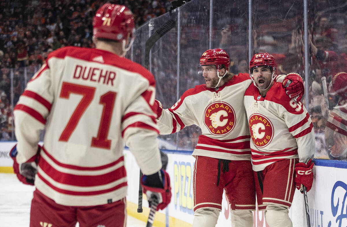 Calgary Flames' Walker Duehr (71), Noah Hanifin (55) and Nazem Kadri (91) celebrate after a goa ...