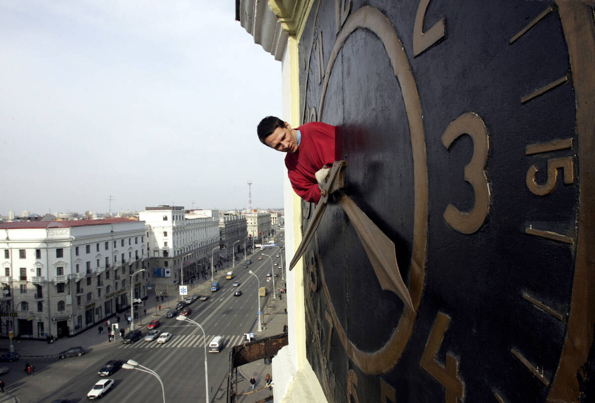 Technician Oleg Ryabtsev performs maintenance work on a clock in Minsk, Belarus, Saturday, Marc ...