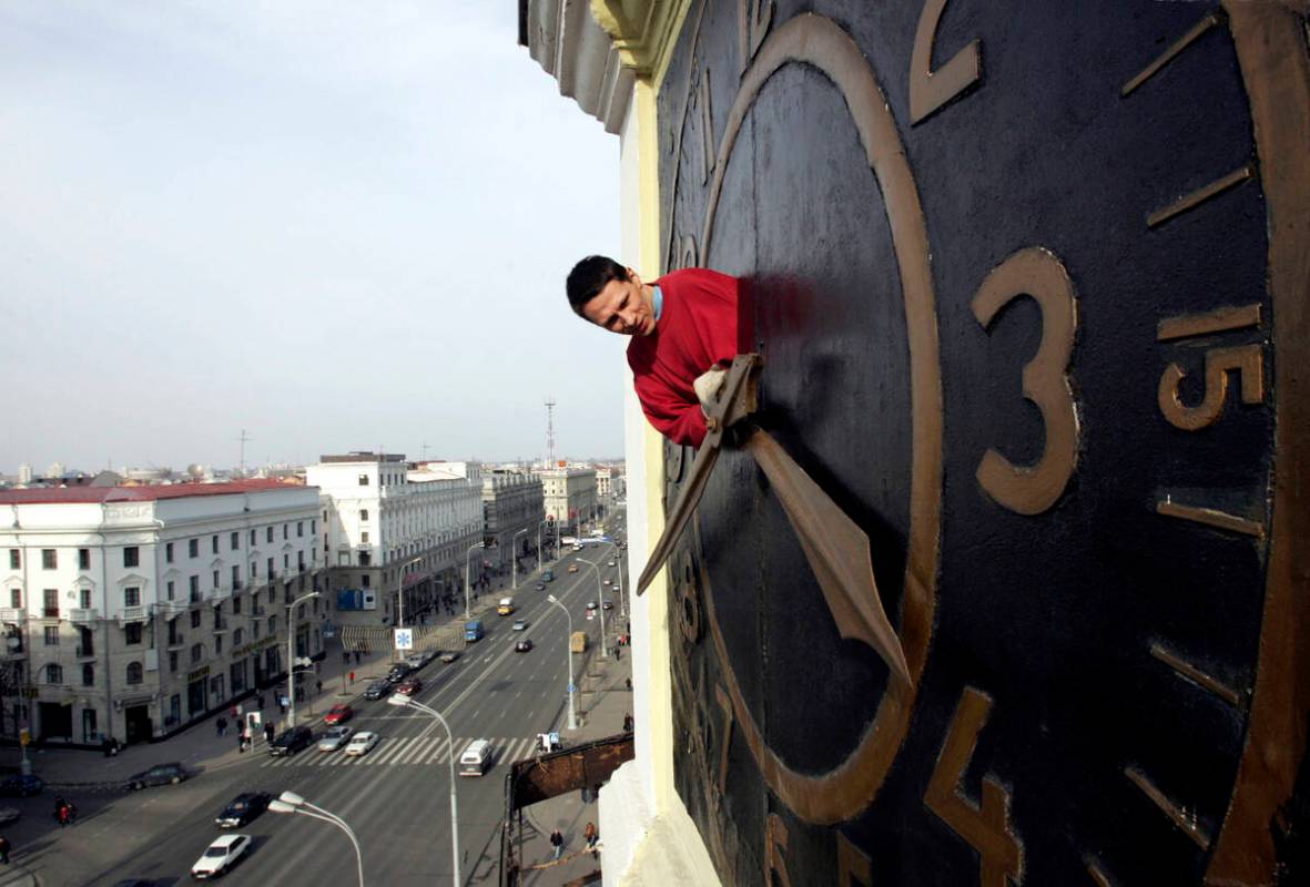 Technician Oleg Ryabtsev performs maintenance work on a clock in Minsk, Belarus, Saturday, Marc ...