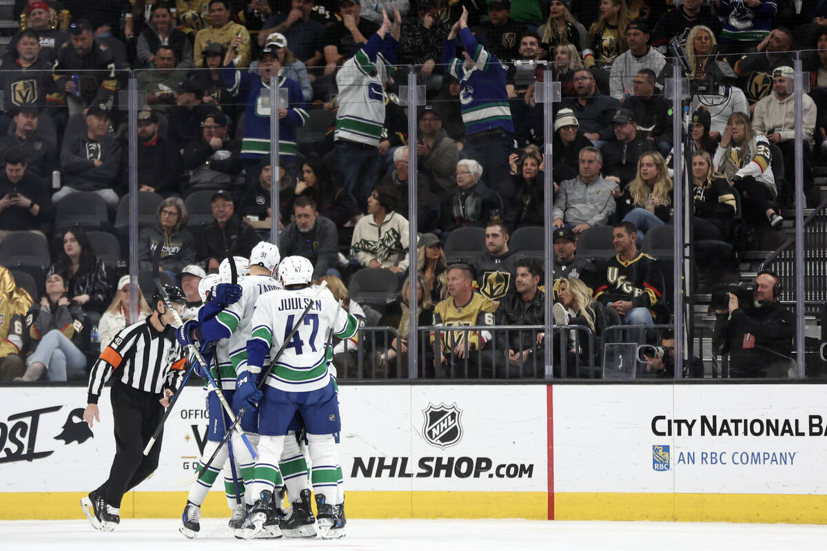 The Canucks celebrate after scoring during the first period of an NHL hockey game against the G ...