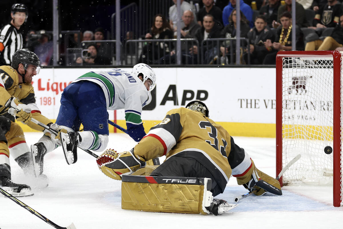Canucks right wing Conor Garland (8) scores a goal on Golden Knights goaltender Adin Hill (33) ...