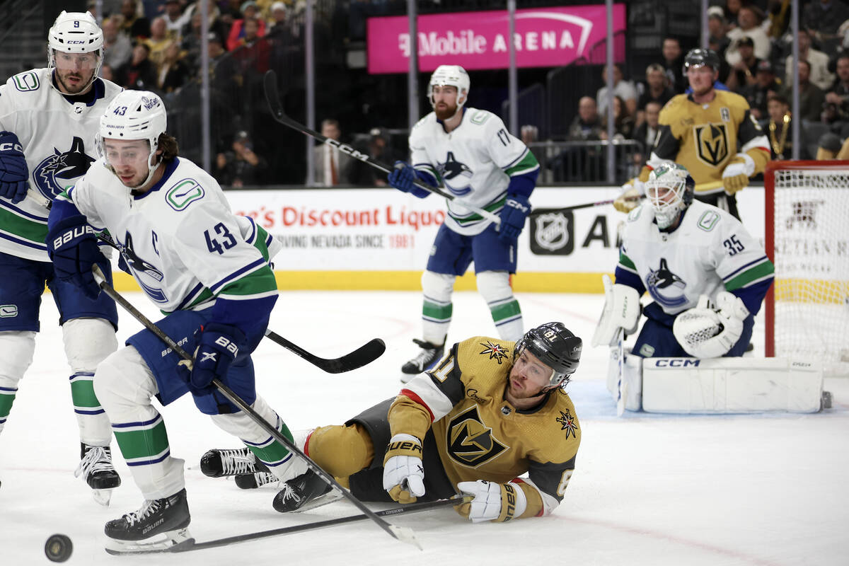Golden Knights right wing Jonathan Marchessault (81) falls to the ice while Canucks defenseman ...