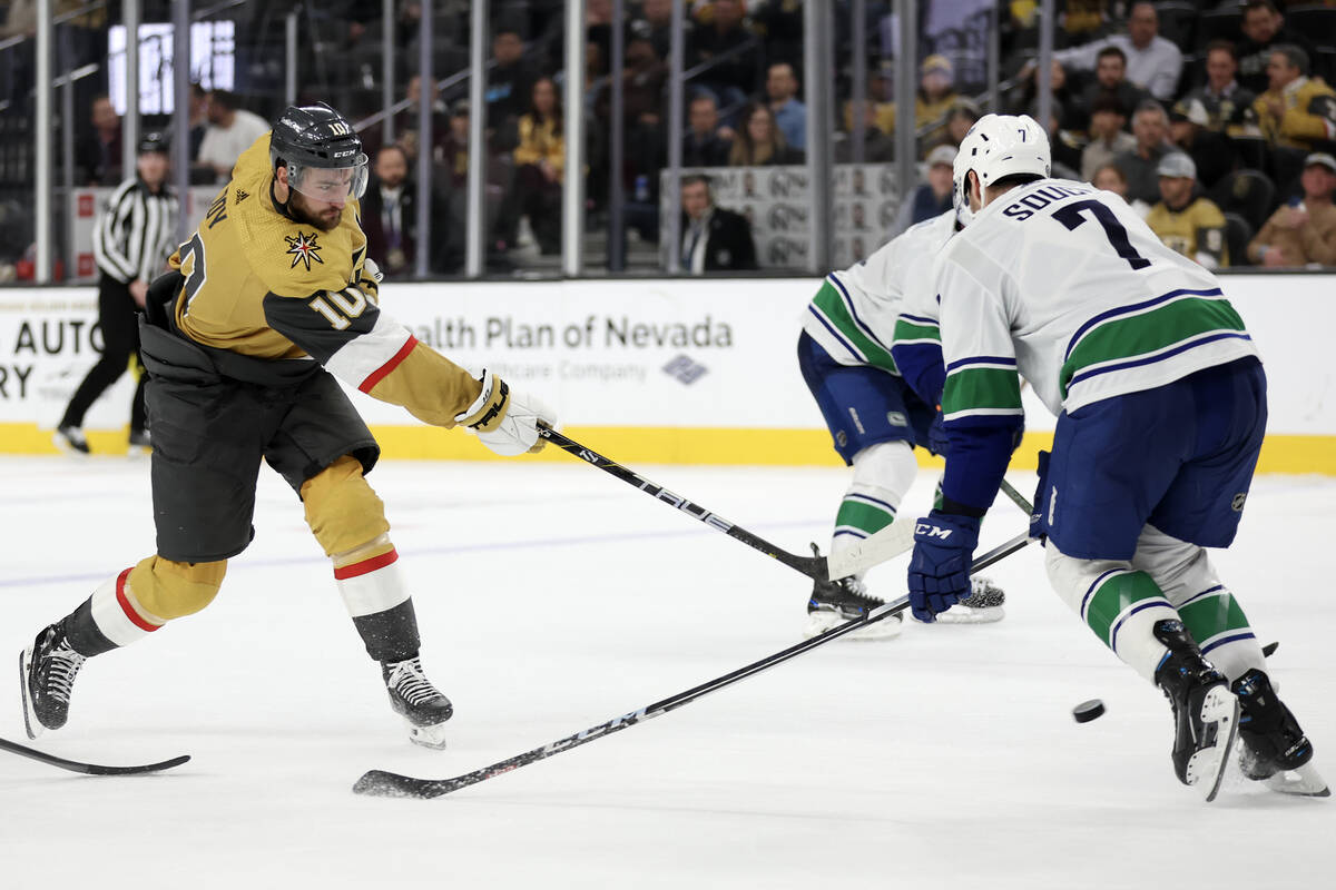 Golden Knights center Nicolas Roy (10) attempts a goal with pressure from Canucks defenseman Ca ...