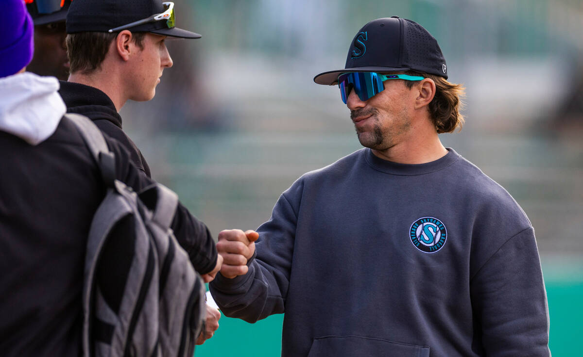 Silverado head coach Jacob Fletcher greets a player near the dugout against Green Valley during ...