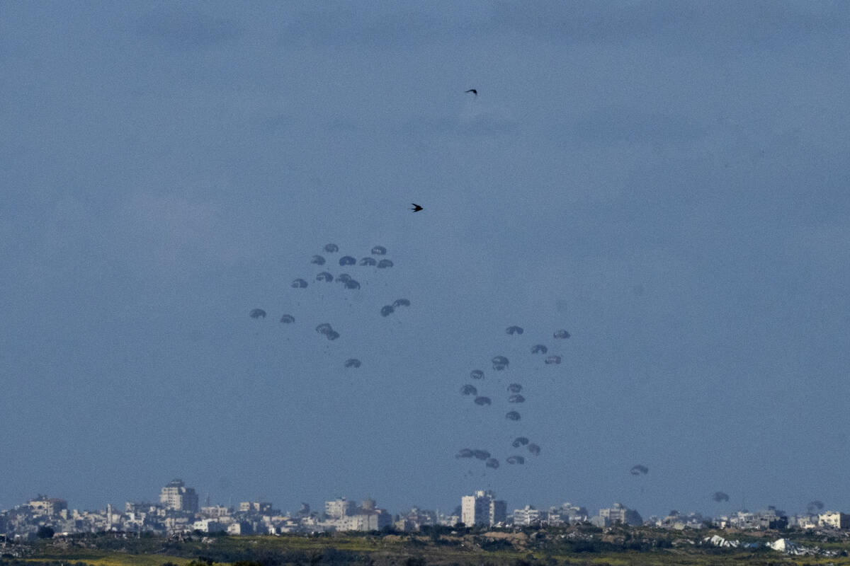 Parachutes drop supplies into the northern Gaza Strip, as seen from southern Israel, Thursday, ...