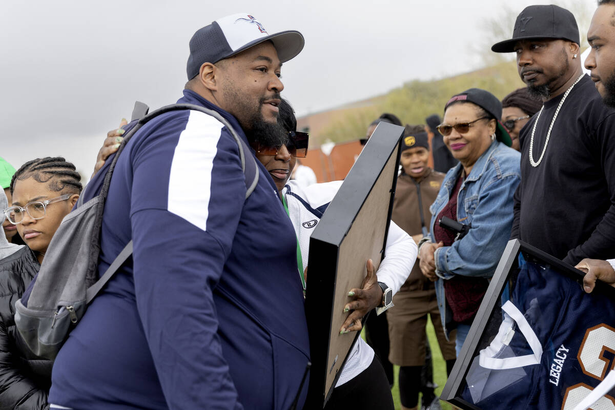 Loved ones of Omarion Wilson, including his mother, Laquinna Wiggins, center, gather for a vigi ...