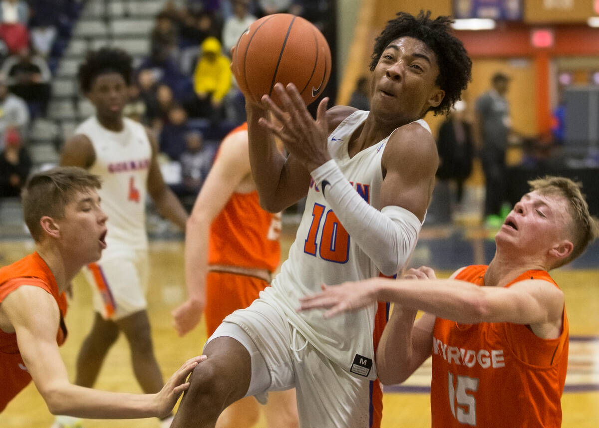 Bishop Gorman junior guard Zaon Collins (10) drives past Skyridge sophomore point guard Nick Ho ...