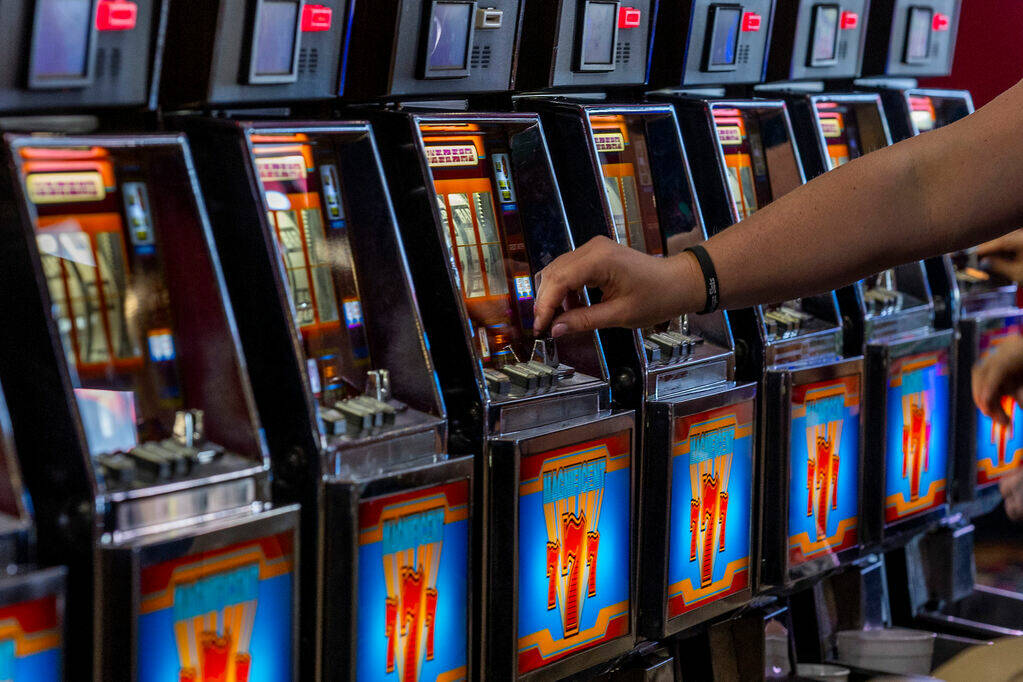 A player inserts a coin into a machine in Slots A Fun, the revamped slots area housing many coi ...