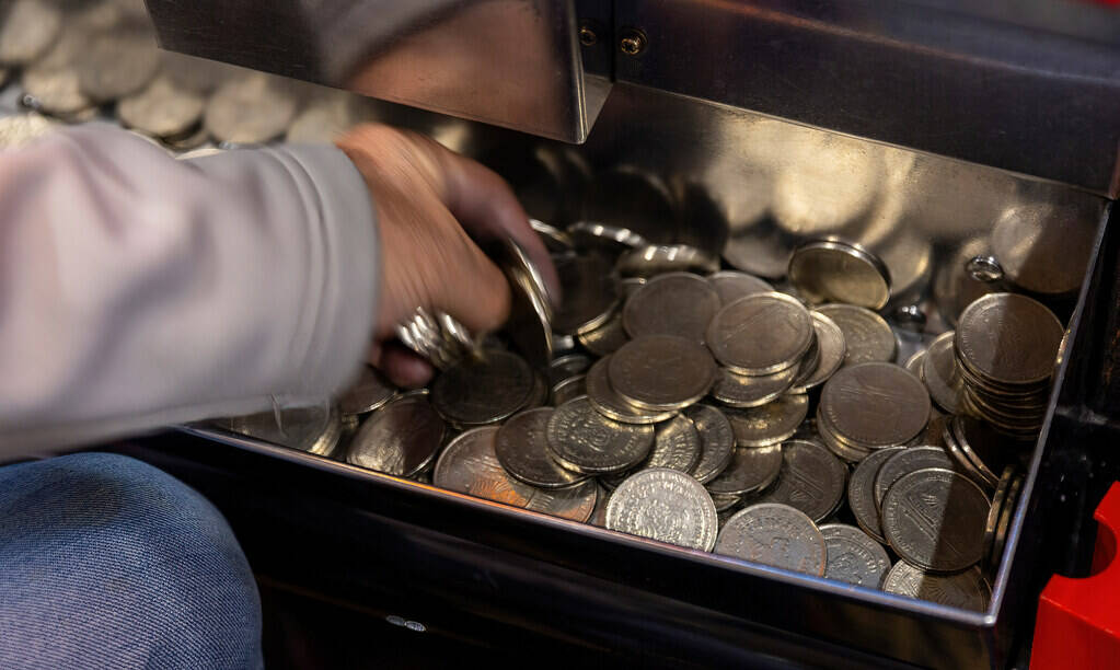 A player grabs $1 coins from the tray at his machine in Slots A Fun, the revamped slots area ho ...